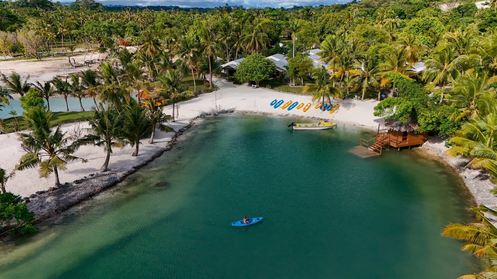 E'Nauwi Beach Resort aerial view β crystal lagoon with kayaks and bungalows on Malekula Island